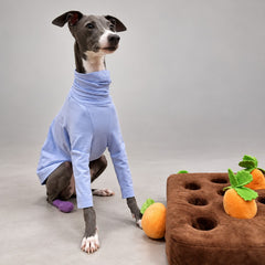 Seated side view showing the lavender cotton turtleneck shirt's neckline, sleeve length and body coverage.