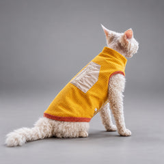 Cat seated in the Golden Yellow waffle fleece vest, showing the back label and red trim.