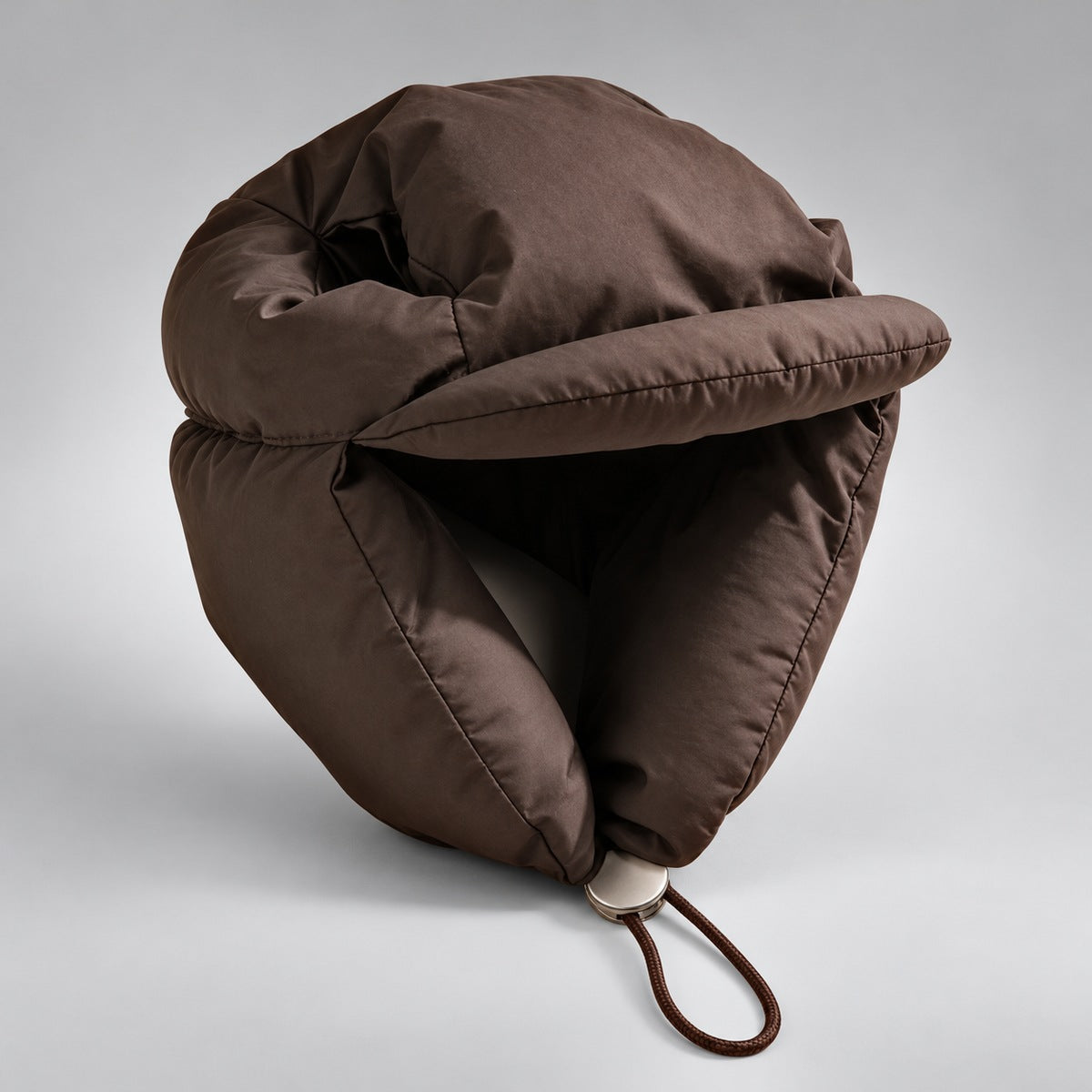 Angled studio view of the brown padded dog hat, showing the curved brim and padded side flaps.