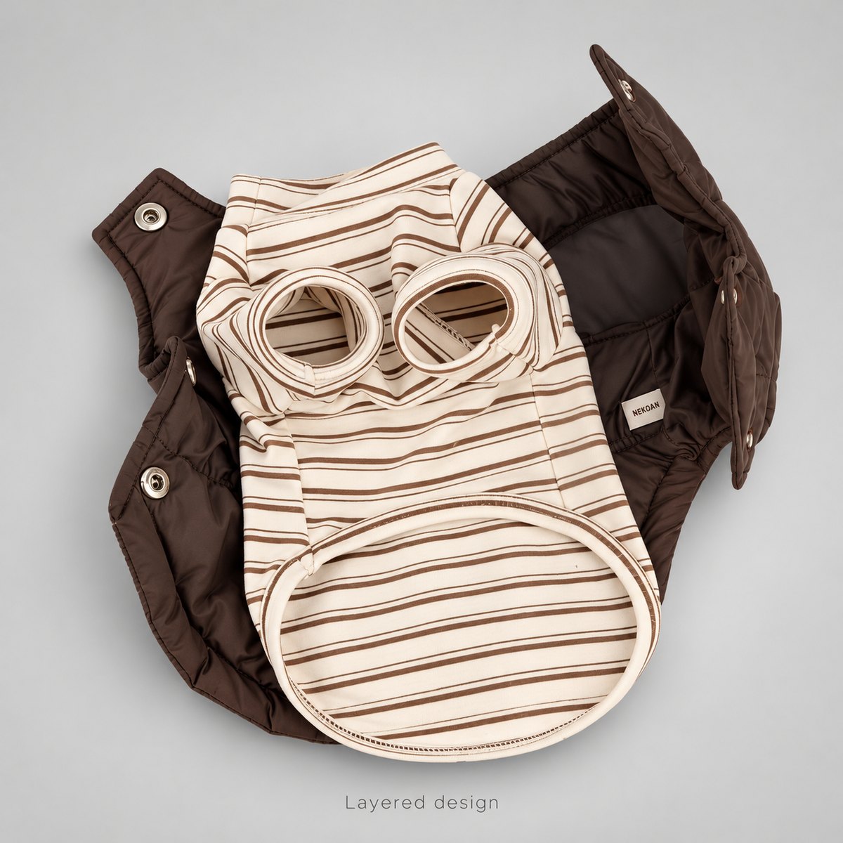 Open brown vest with the cream striped shirt laid inside, showing the separate layers and snap hardware.