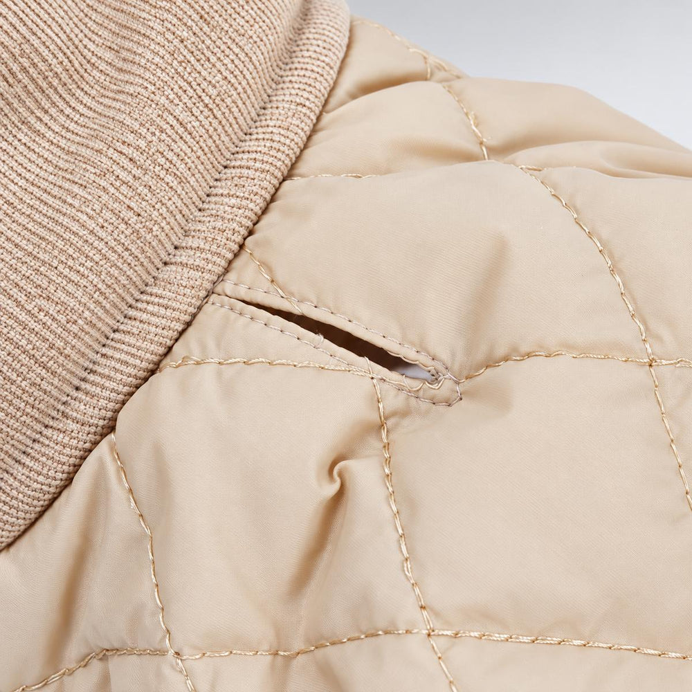 Close-up of the Beige quilted coat showing the ribbed collar and stitching.