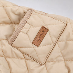 Close-up of the Beige quilted coat showing the pocket, label and diamond stitching.