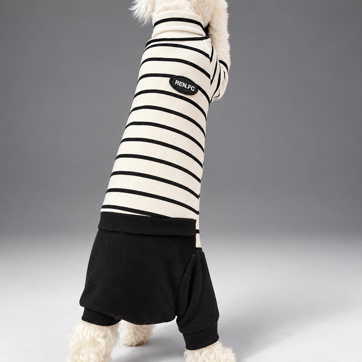 Cat wearing the Classic Stripe onesie, standing in rear view.