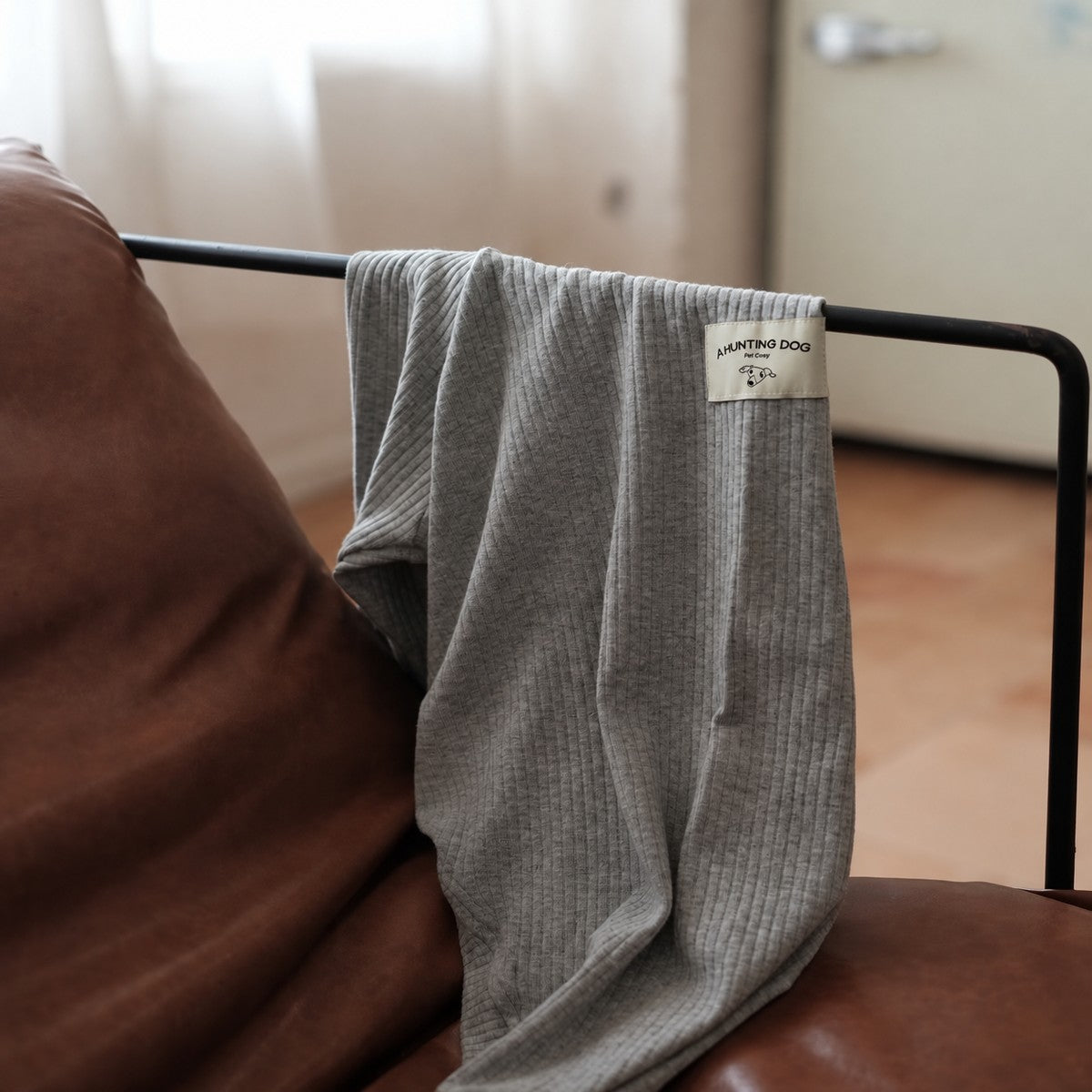 Heather gray ribbed turtleneck draped over a chair, with a close view of the neckline and knitted texture.