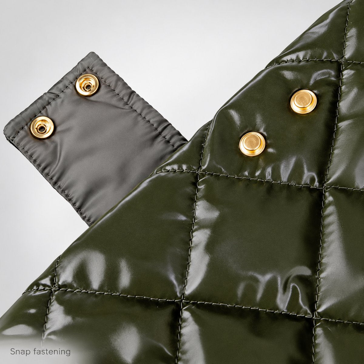 Open side fastening showing the gold-tone snap hardware and reverse of the quilted tab.