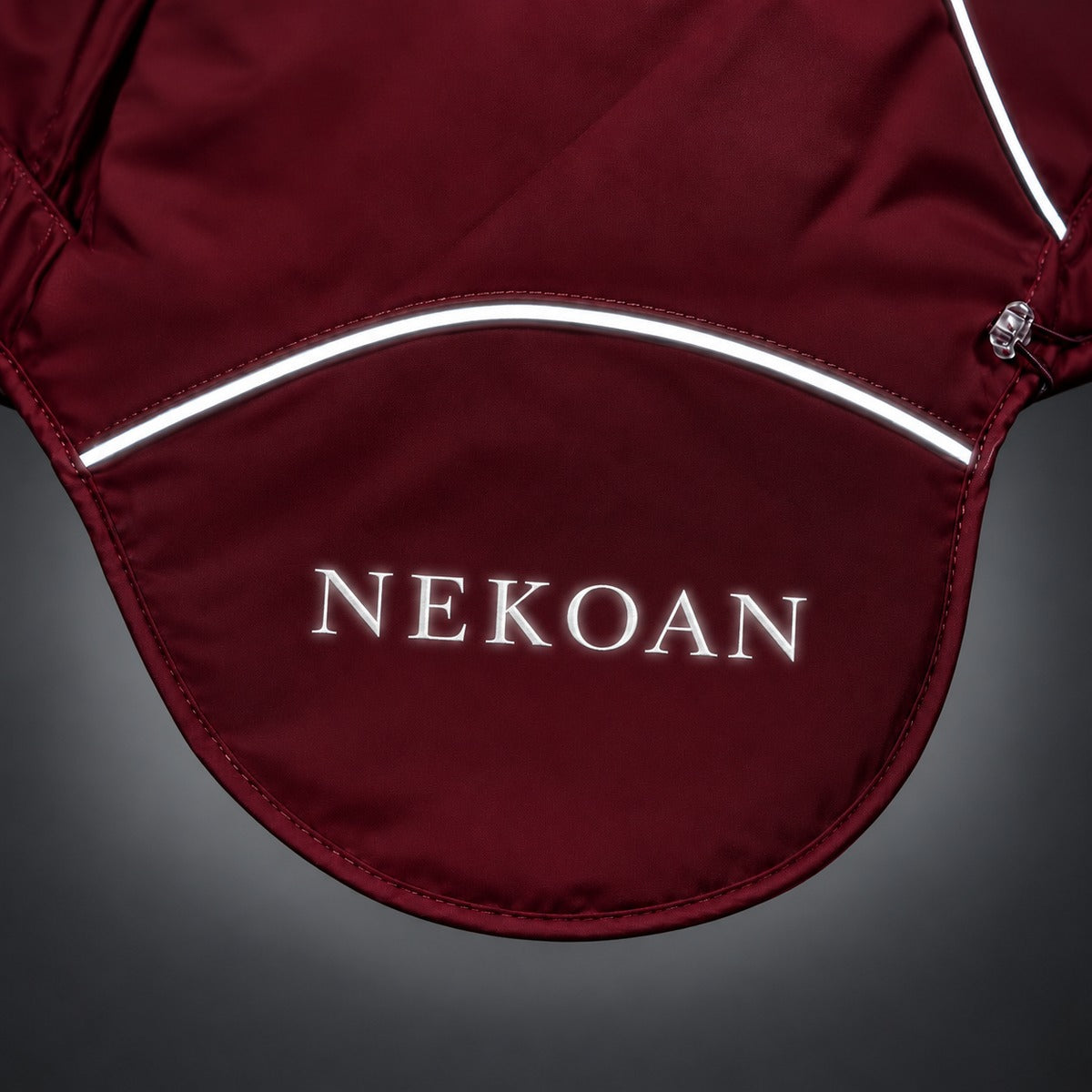 Close-up of the Burgundy dog jacket showing the back panel, logo and contrasting piping.