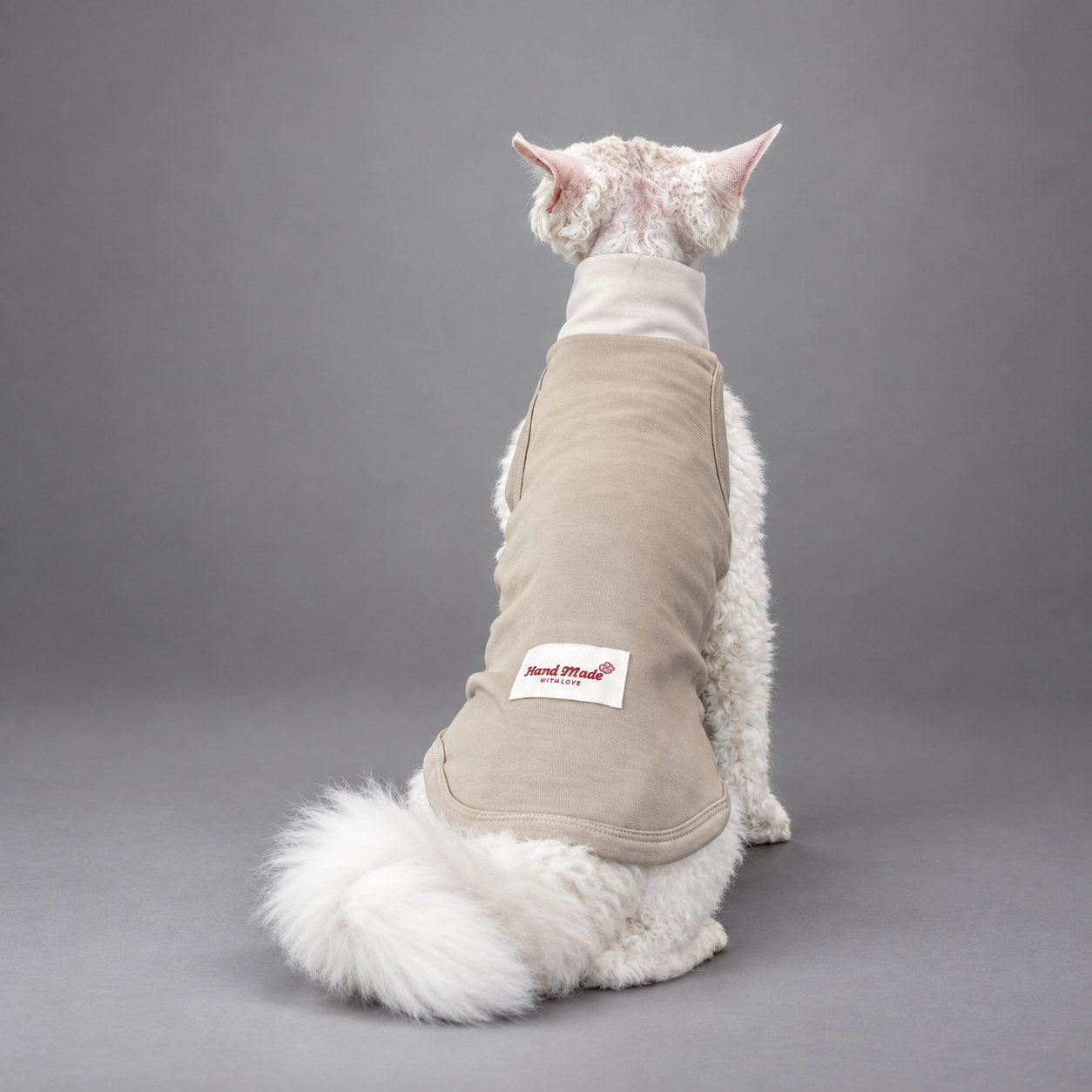 Cat wearing the Soft Taupe vest, seated in rear view.